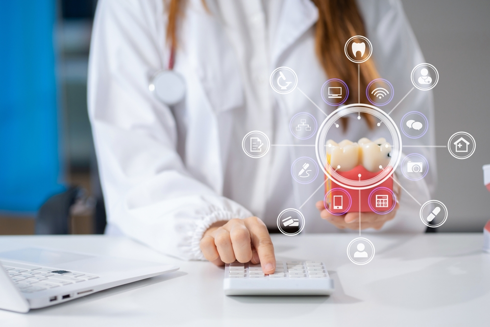 Dentist in a white coat demonstrates a tooth model, with a laptop nearby and circular icons illustrating dental care services around the model.